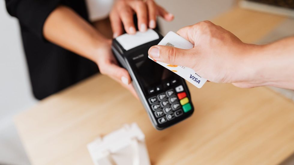 person swiping a card with a cashier