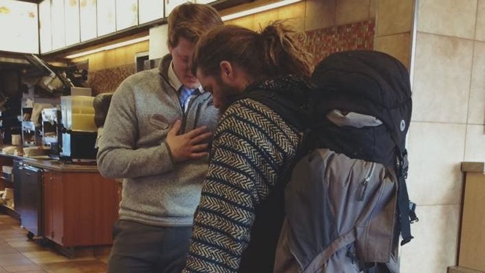 restaurant manager praying with a homeless man