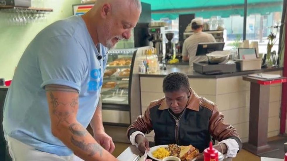 restaurant owner serving a meal to a customer