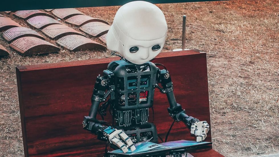 Robot reads a book on a park bench 1024x576