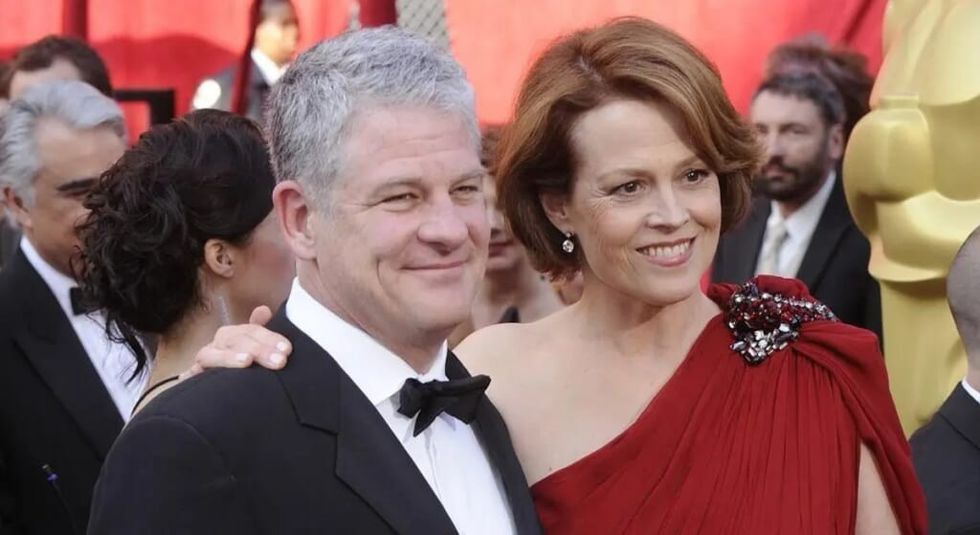 Sigourney Weaver in red dress with husband Jim Parsons in tux.