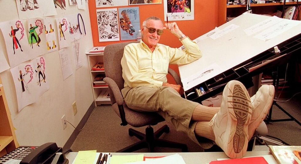 Stan Lee sitting in his office in a chair with his feet up.