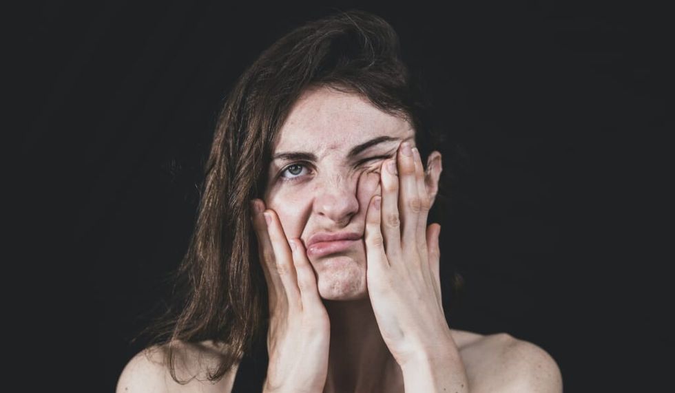 stressed out young woman looks into lens