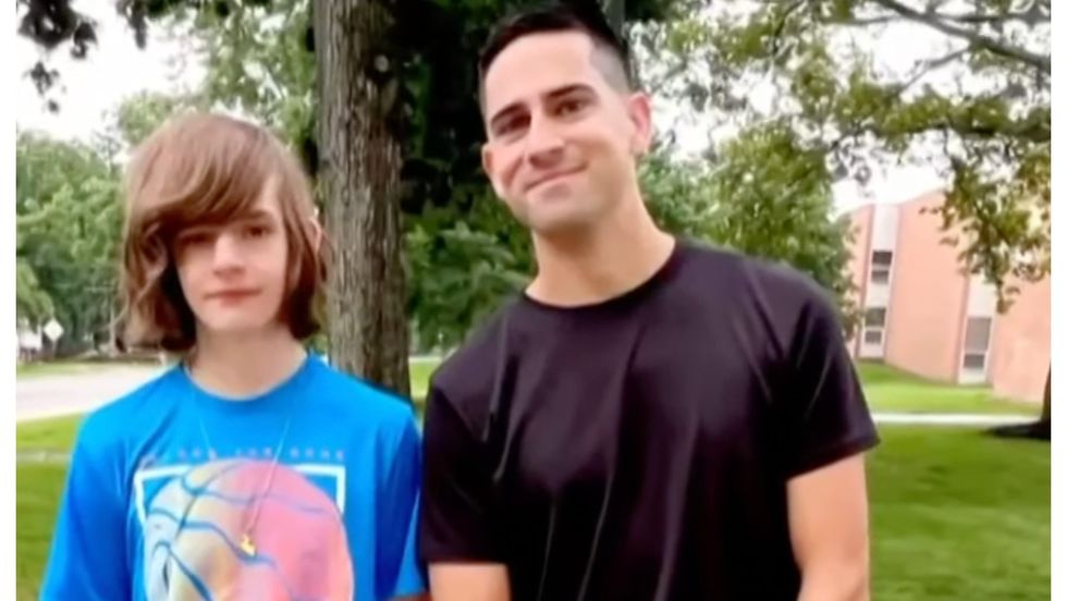 teen boy standing with his high school teacher