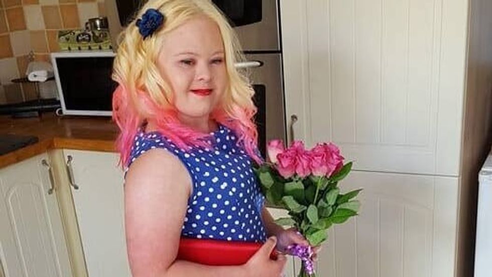 teen girl in a blue dress holding roses