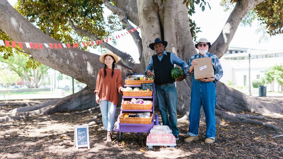 three farmers standing with their produce