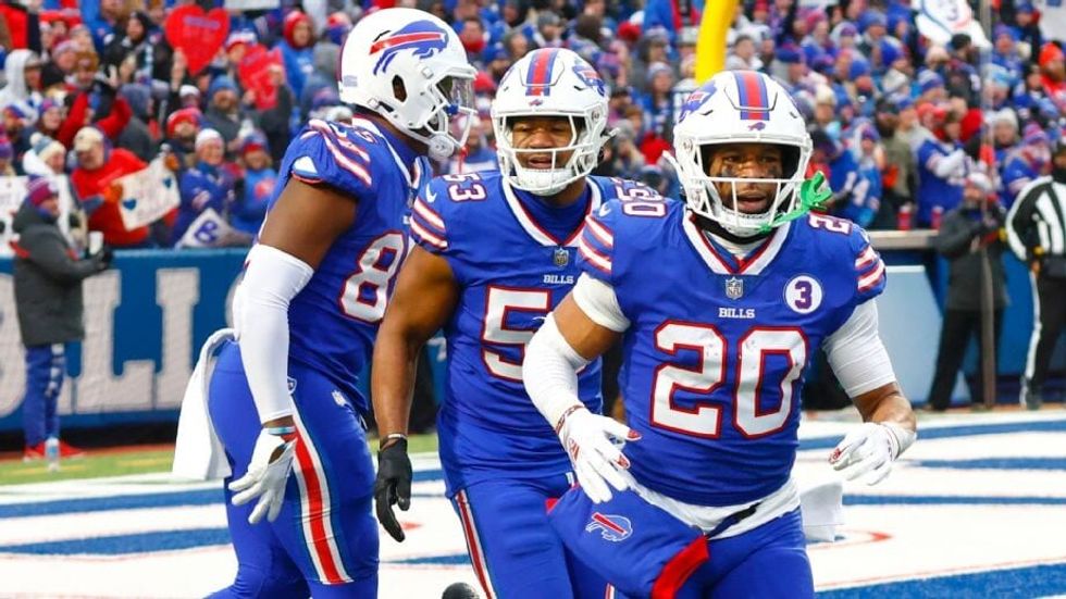 three football players in blue uniforms
