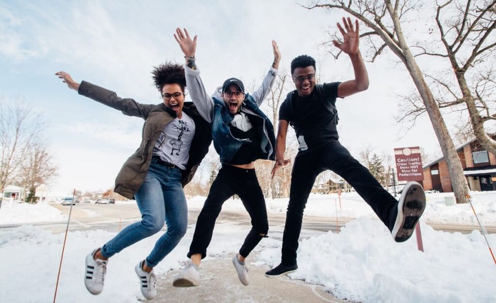 three friends dance and pose together