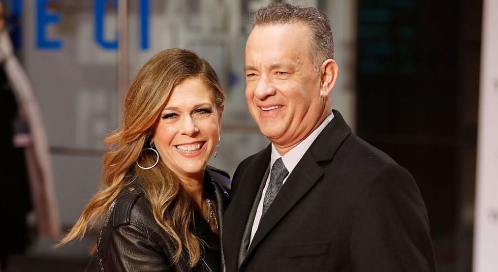 Tom Hanks in dark jacket with wife Rita Wilson in black leather jacket.