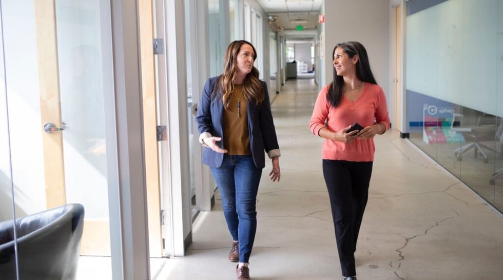 two friends at work walk together