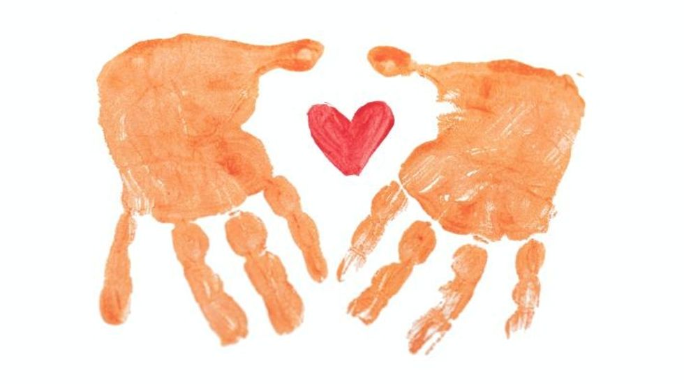 two hand prints around a red heart