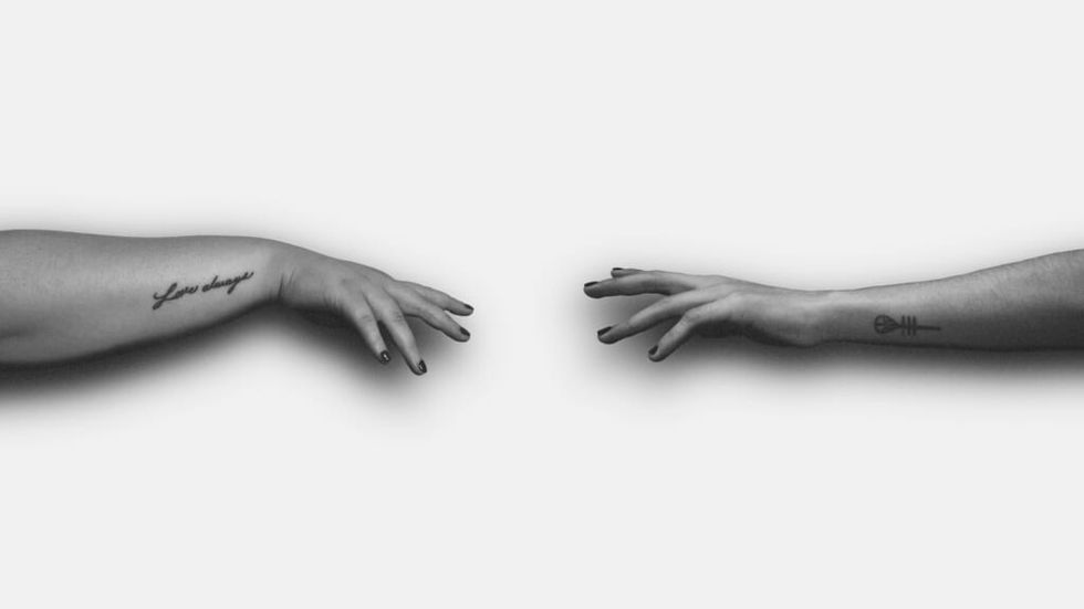 two hands reaching for each other
