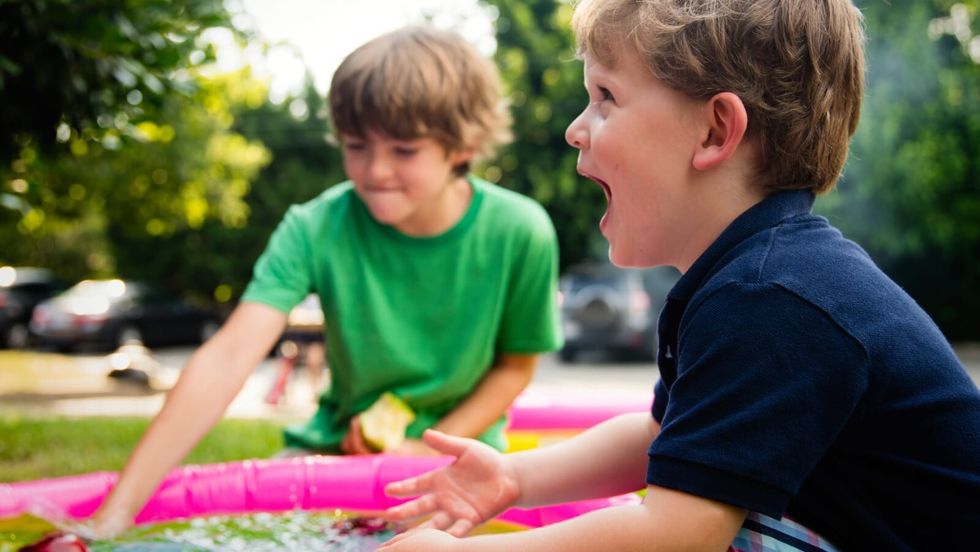 two kids playing in a kiddie pool