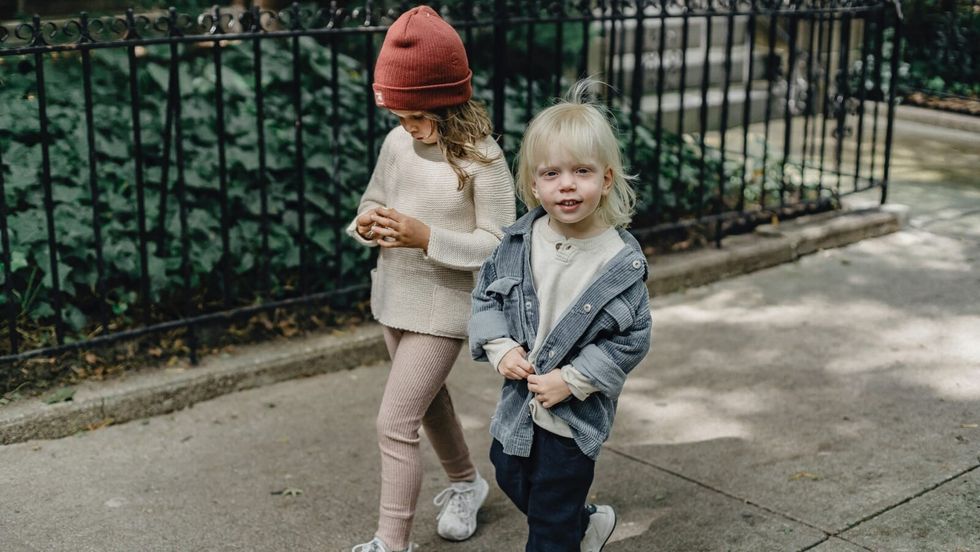 two little girls walking on the road