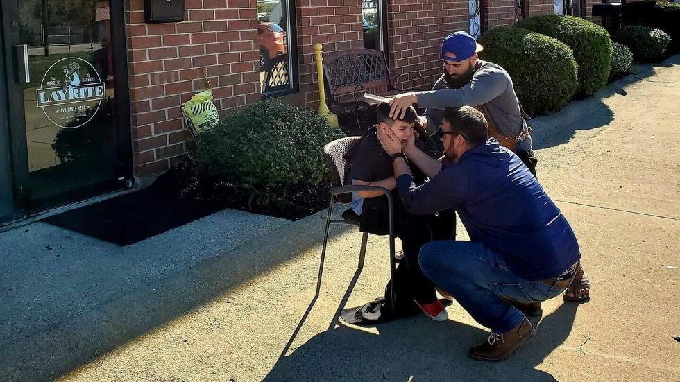 two men and a little boy sitting on a chair