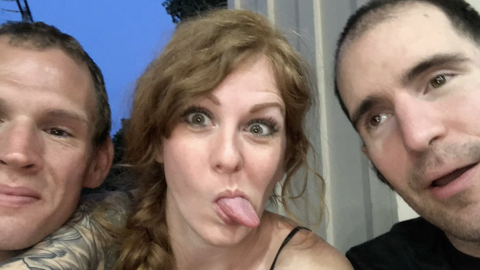 two men and a woman taking a photo