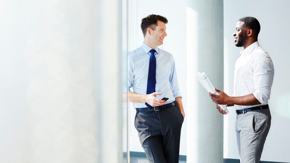 Two men in suits at office talking