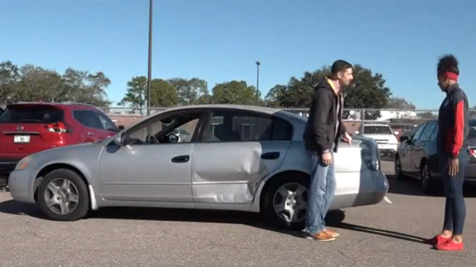 two people standing in front of a silver car
