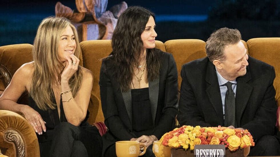 two women and one man sitting on a couch