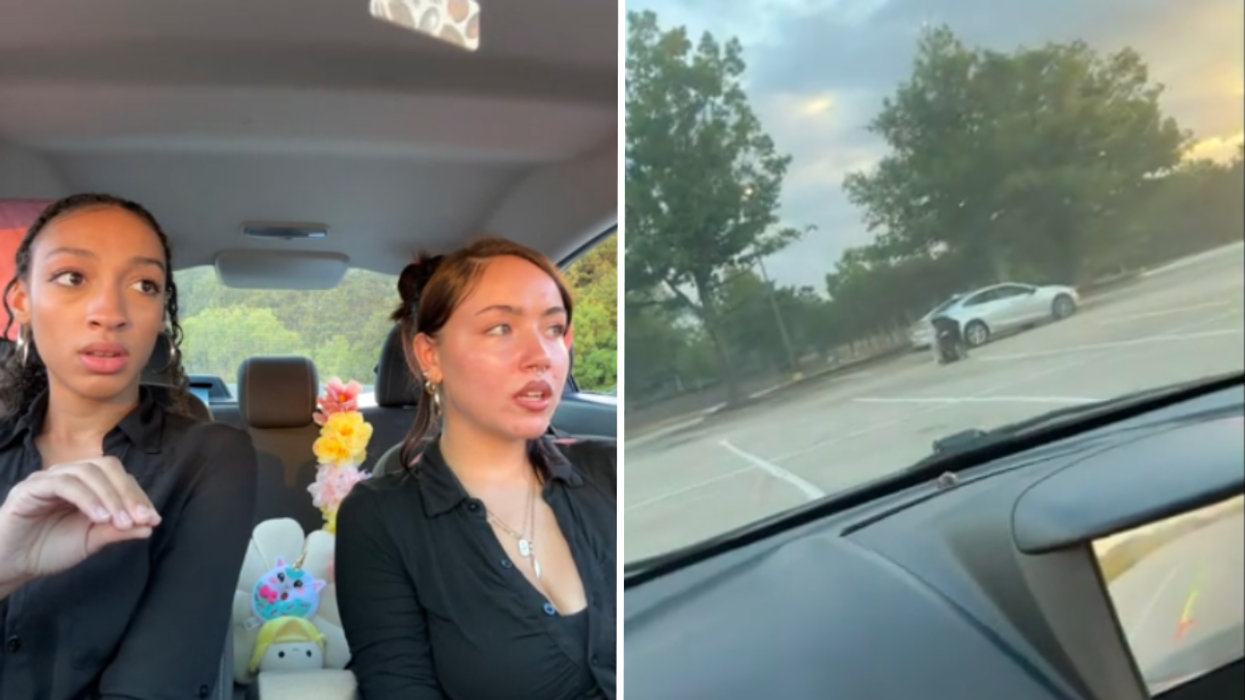 Two women sitting in a car and a white car in an empty parking lot.