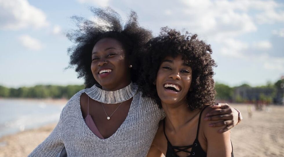 two women smile outdoors
