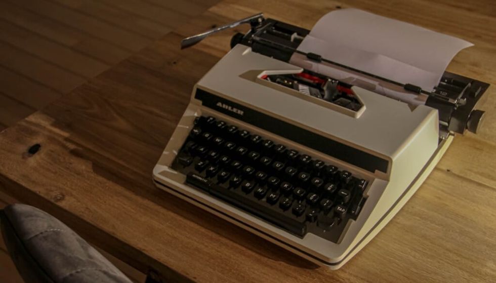 typewriter sitting on wooden table