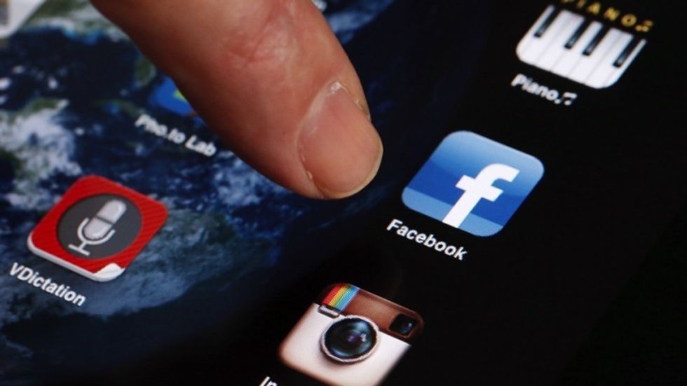 User clicking on the facebook app on smartphone. Top 5 Time Wasters