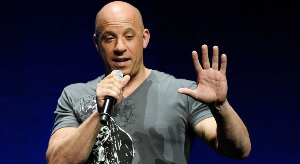 Vin Diesel holding a microphone during an interview.