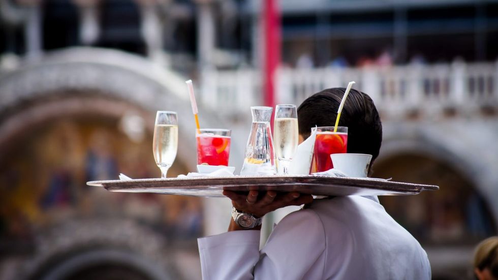 waiter carrying a tray of drinks