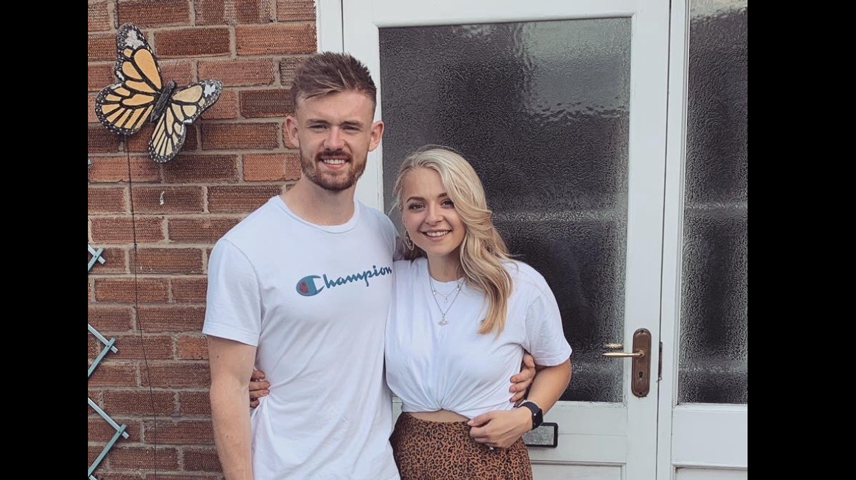 Woman and her husband standing in front of their house.