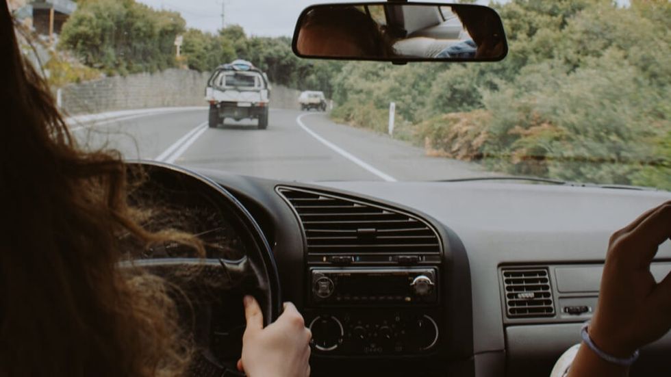 Woman behind wheel driving a car