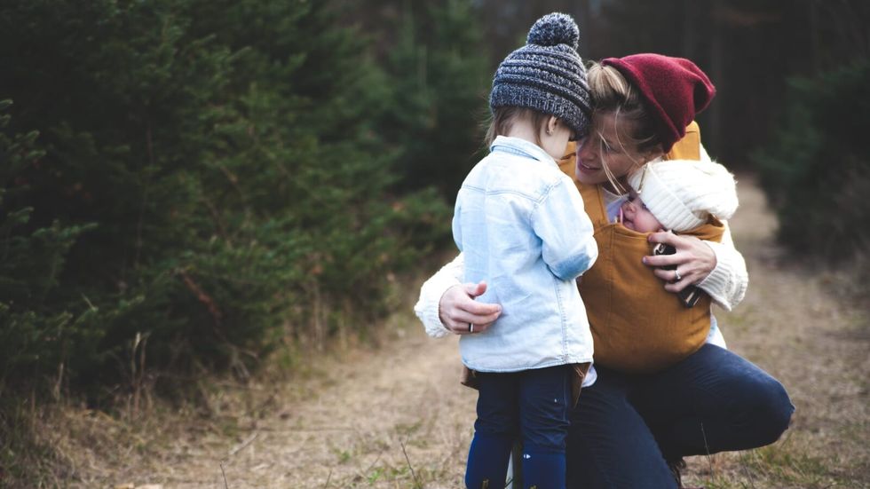 woman hugging 2 little children