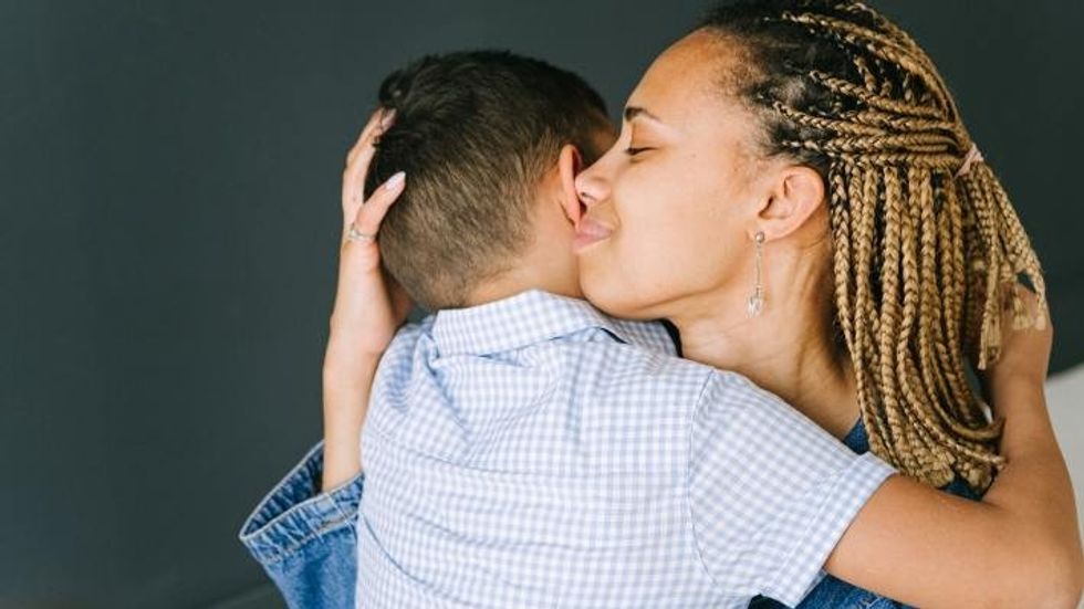 woman hugging a young boy