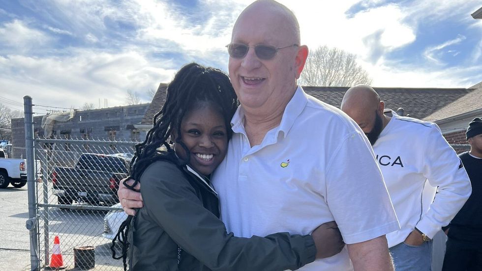 woman in a hoodie hugging a man in a white shirt