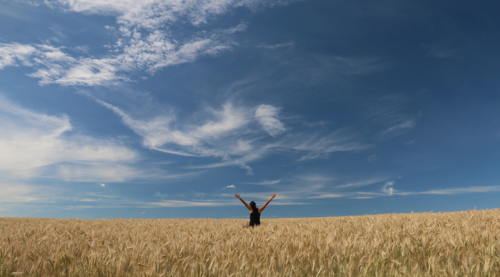 woman in field celebrating