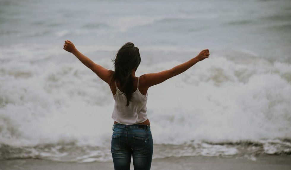 woman lets the ocean serenade her spirit