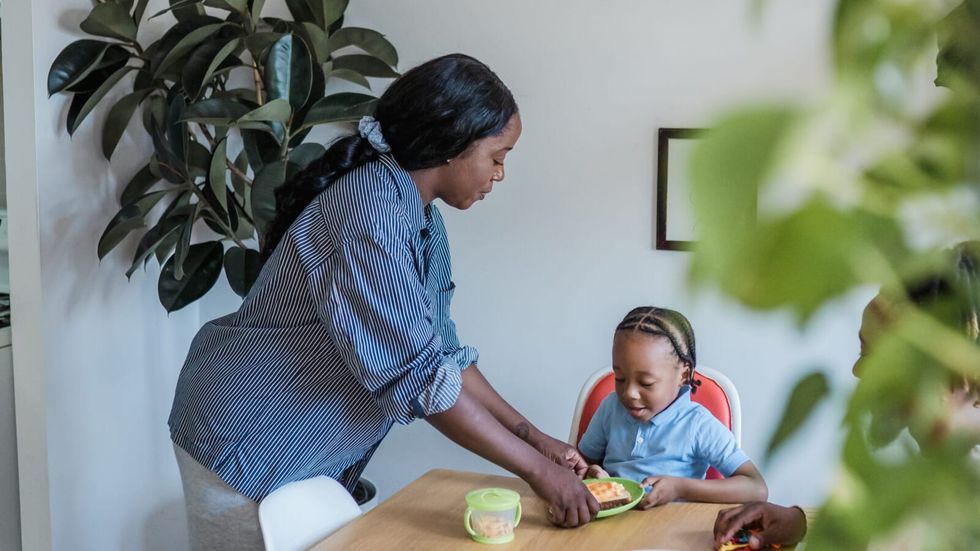 woman placing food before a little boy