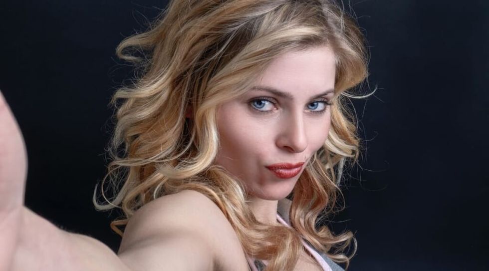 Woman pursing lips taking a selfie by Sander Sammy on Unsplash