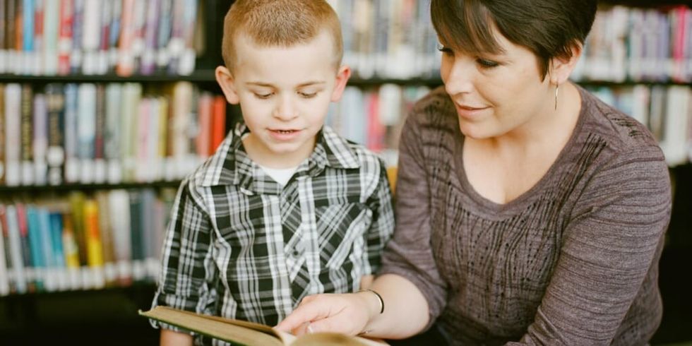 Woman reading book to young booy by Adam Winger on Unsplash
