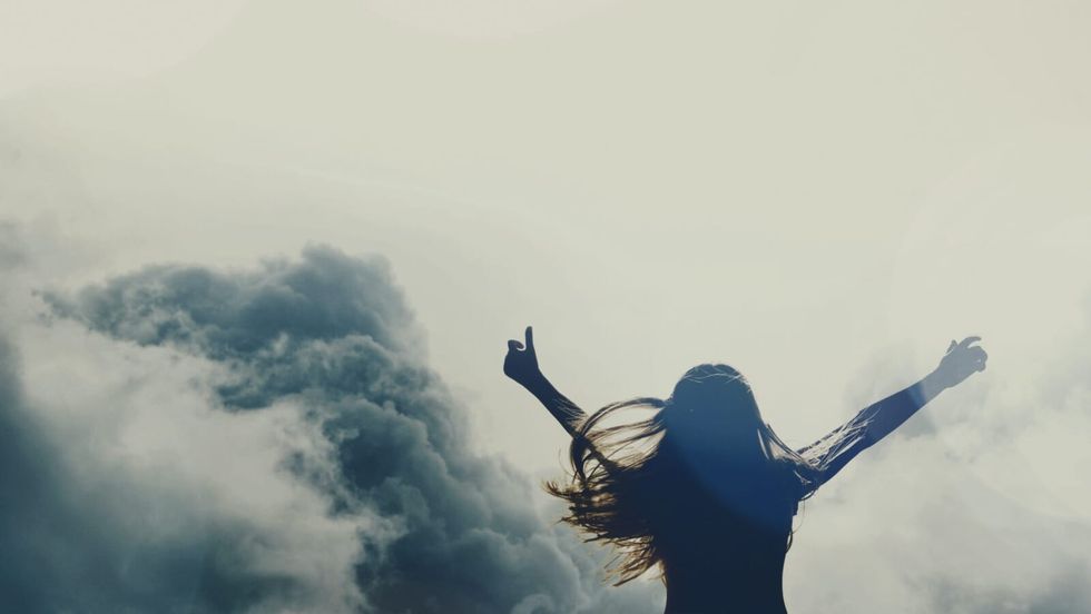 woman's silhouette with her arms raised