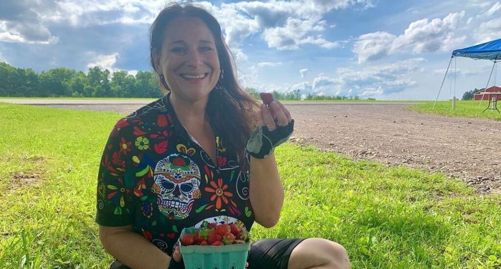 woman sits with strawberries