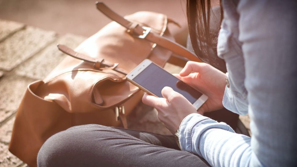 woman sitting on the ground on phone