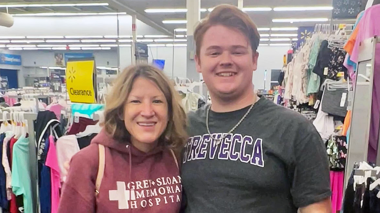 Woman standing with a young man.