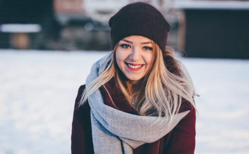 woman stands outside smiling