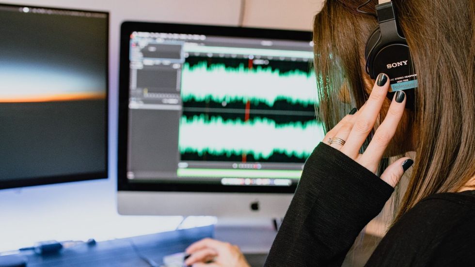 woman wearing headphones in front of a computer