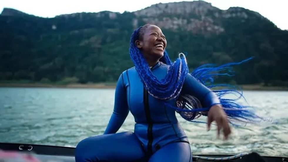 woman with blue hair sitting on a boat