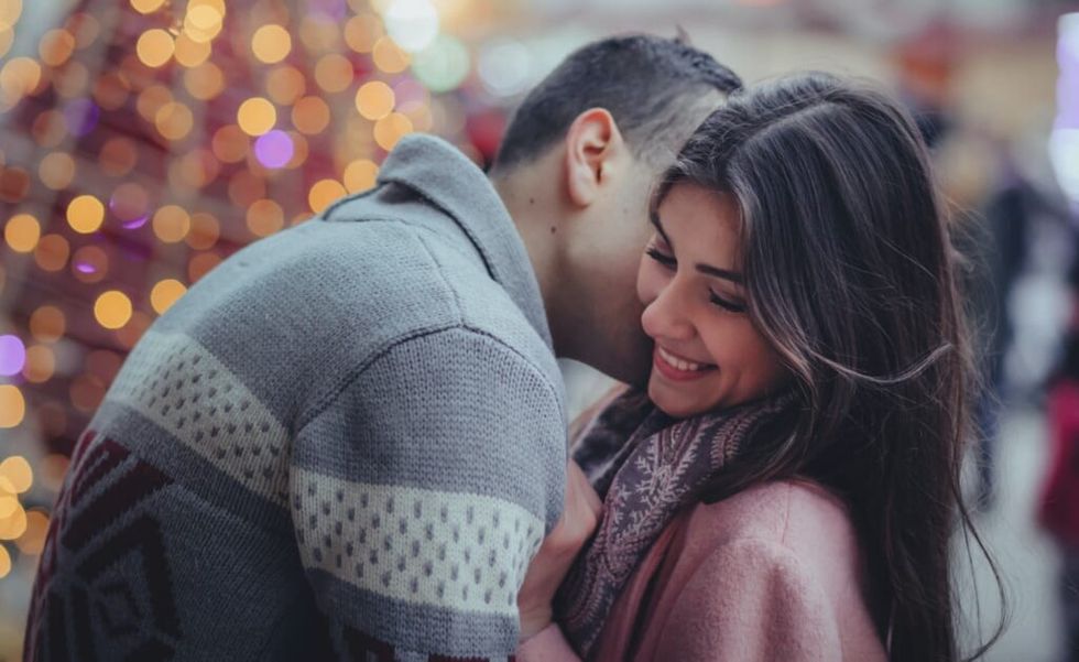young couple flirting outside during christmas