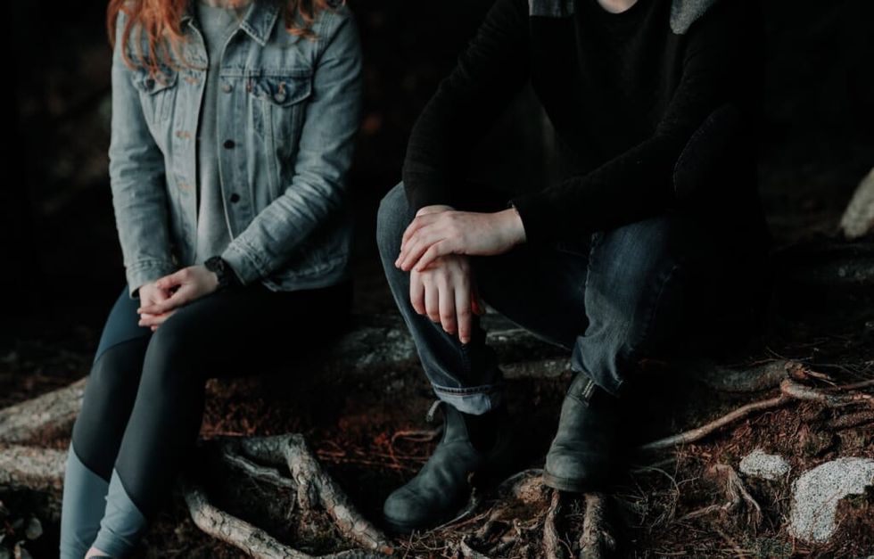 young man and woman sit together outside