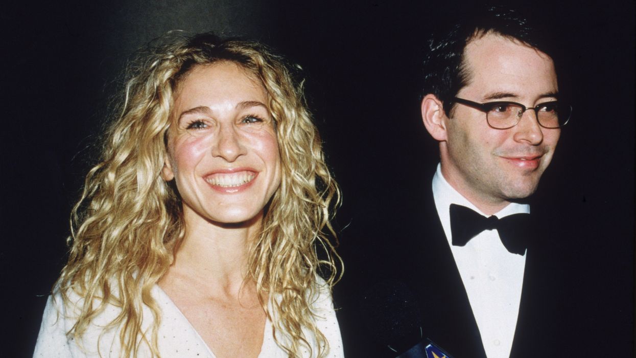 Young Sarah Jessica Parker wearing her hair down and with a white dress next to husbandand Matthew Broderick on the red carpet.