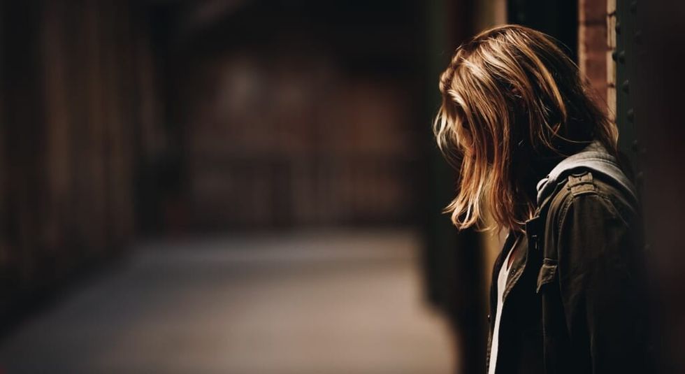 young woman in allley way sad